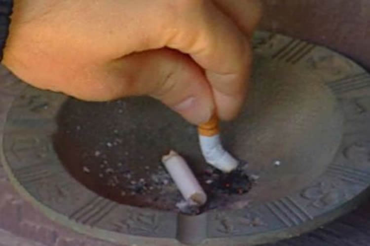 Image shows someone putting out a cigarette.