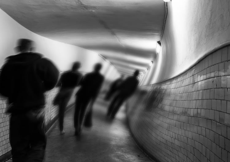 Image shows shadow people in a tunnel.