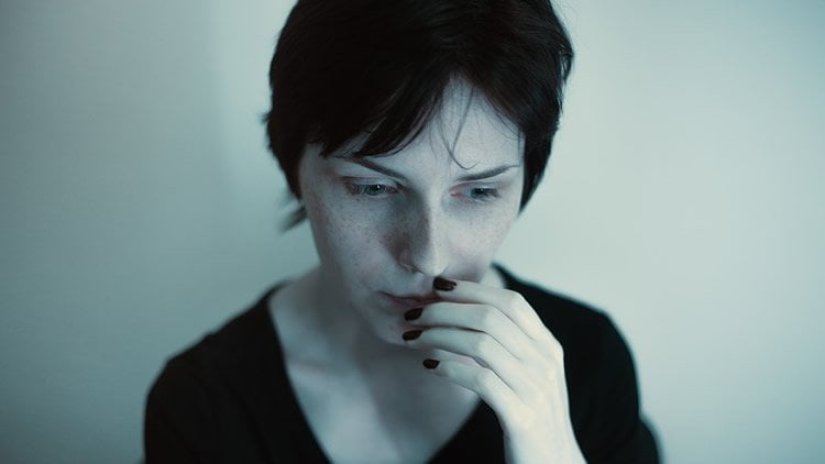 Image shows a anxious looking woman.