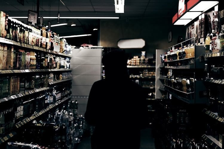 Image shows a person buying alcohol.