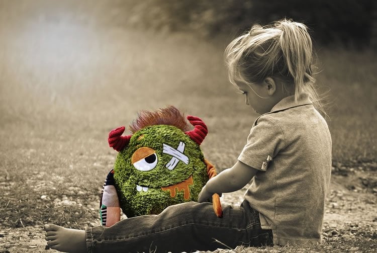 Image shows a little girl and a cuddly toy.