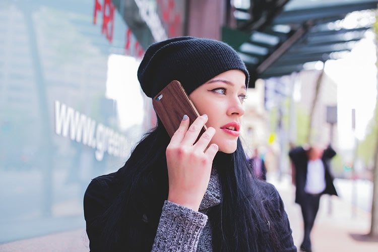 Image shows a woman talking on a phone.