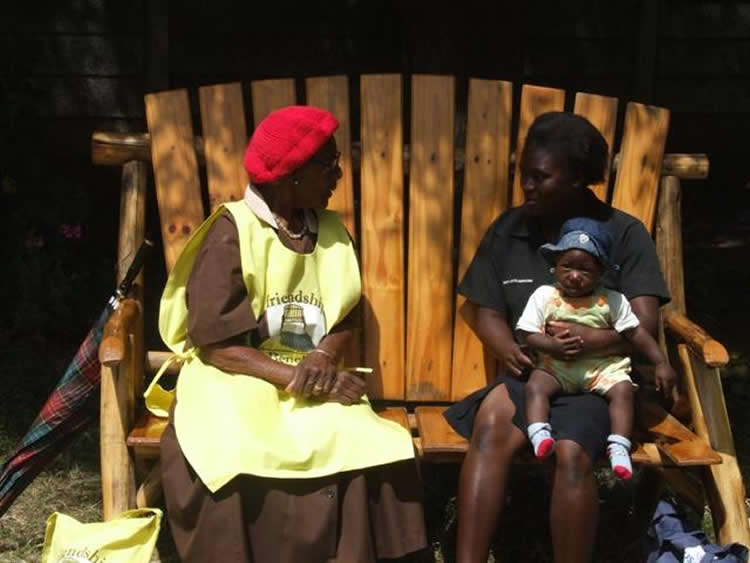 Image shows two women talking on the friendship bench.