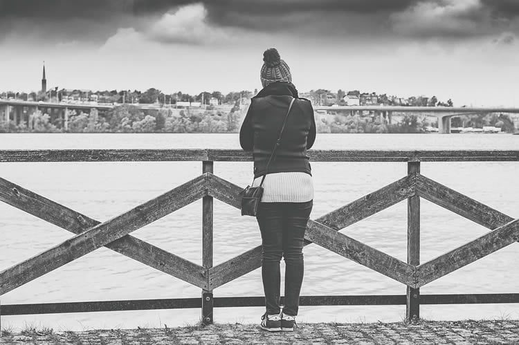 Image shows a woman on a bridge.