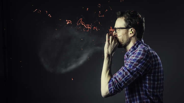 Image shows a man blowing up a balloon.