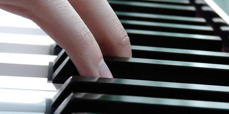 Image shows a person playing piano.