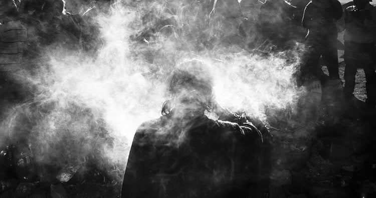 Image shows a person surrounded by smoke.