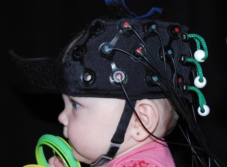 Image shows a baby in an EEG cap.