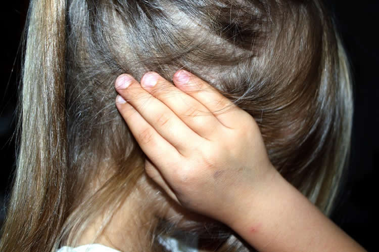 a girl covering her ears.