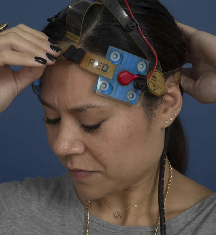 Image shows a woman using the tDCS equipment.