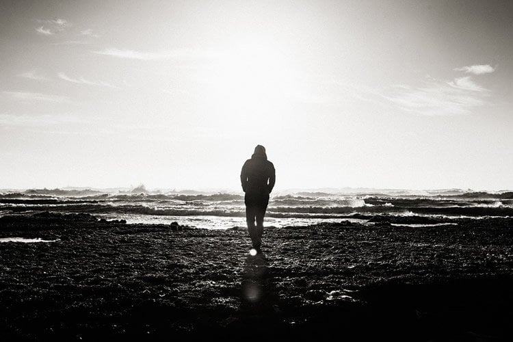 Image shows a man walking with his back to the camera.