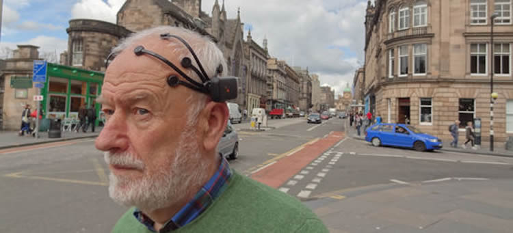 Image shows a man in an EEG cap.