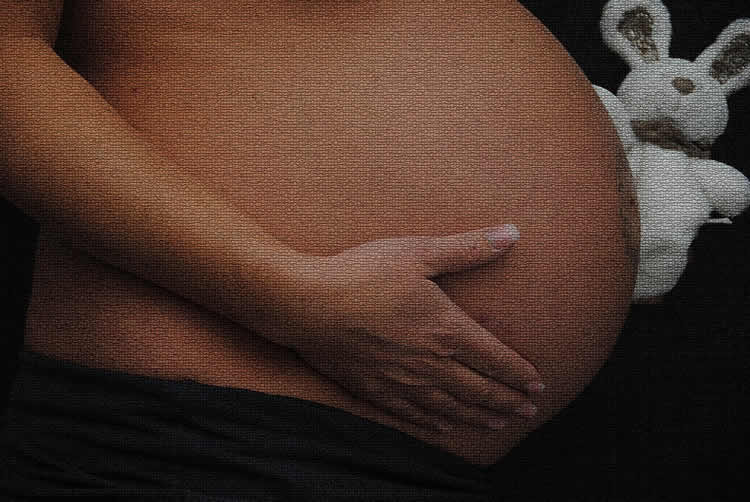Image shows a pregnant woman's belly.