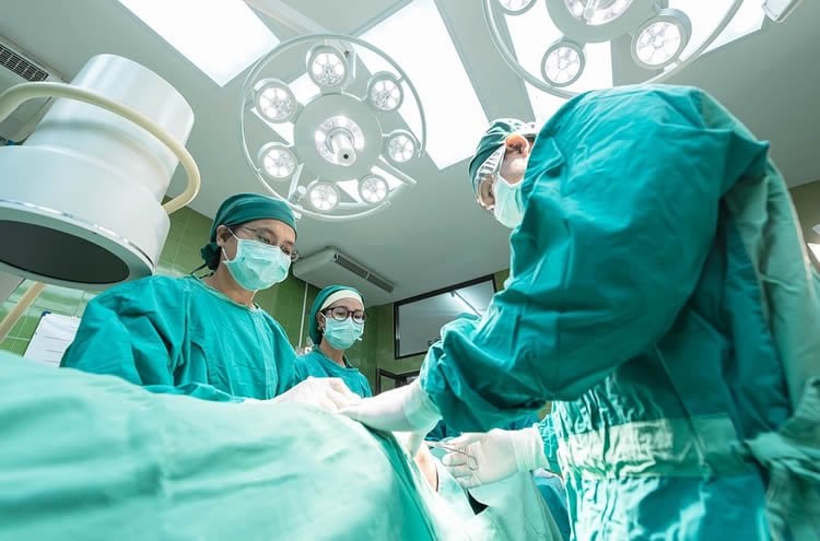 Image shows surgeons operating on a person.