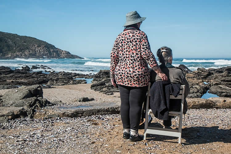 Image shows old people on a beach.