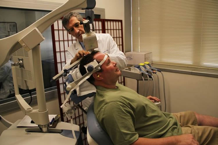 Image shows the research applying tms to a depression patient.