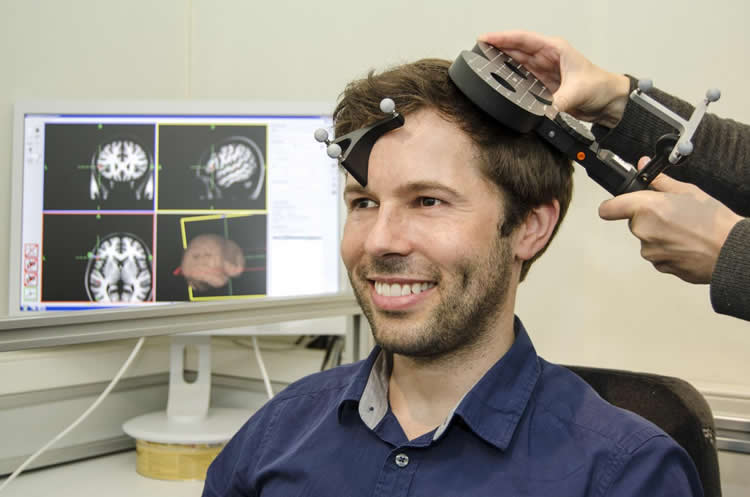 Image shows a person with a TMS machine.