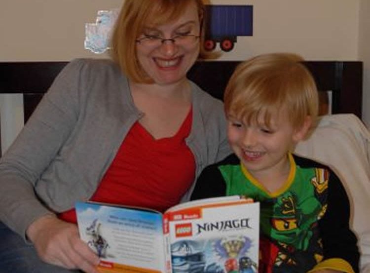Image shows a mom and child reading.