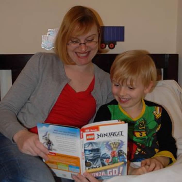 Image shows a mom and child reading.