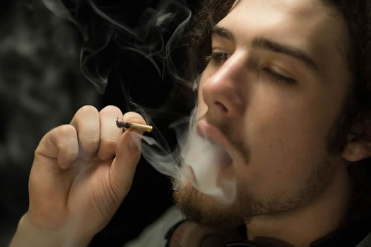 Image shows a person smoking.