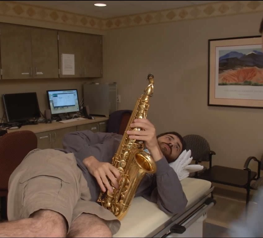 Image shows the patient with his saxophone.