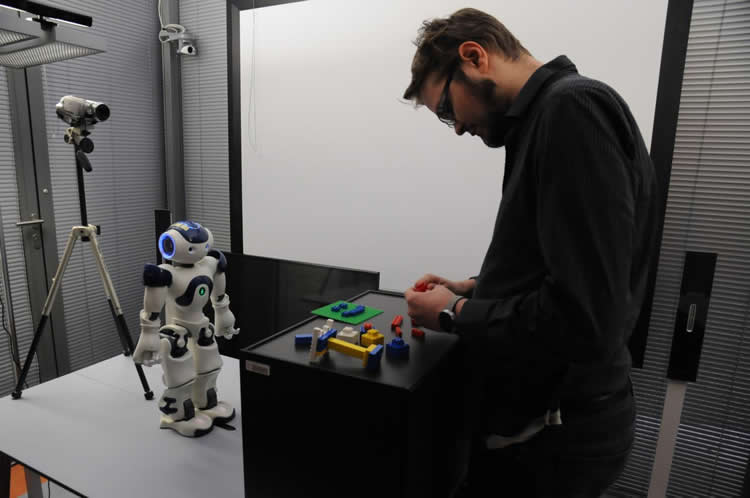 Image shows a person and robot.