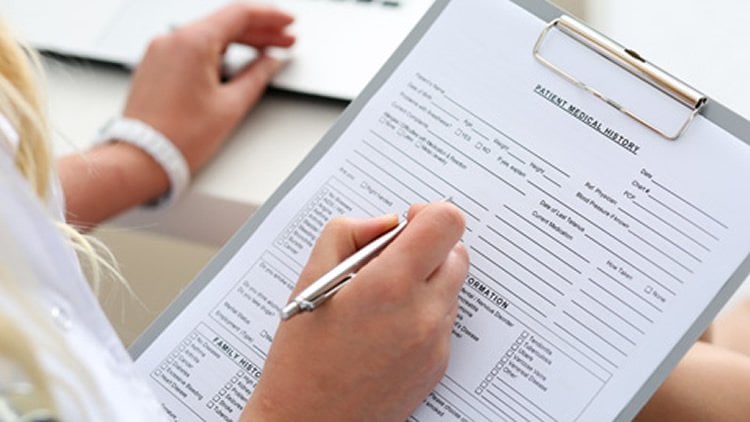 This image shows a person filling out a medical document.