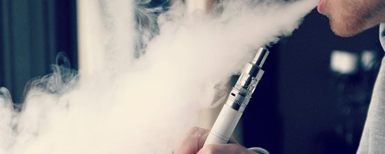 Image shows a person smoking a vape.