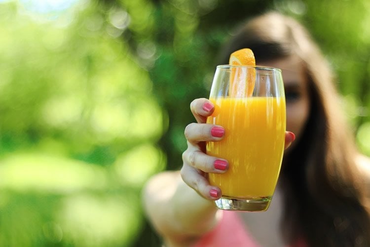 Image shows a glass of orange juice.