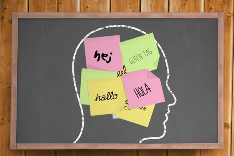 Image shows a head with post-it noted stuck on it. The notes read "hello" in different languages.