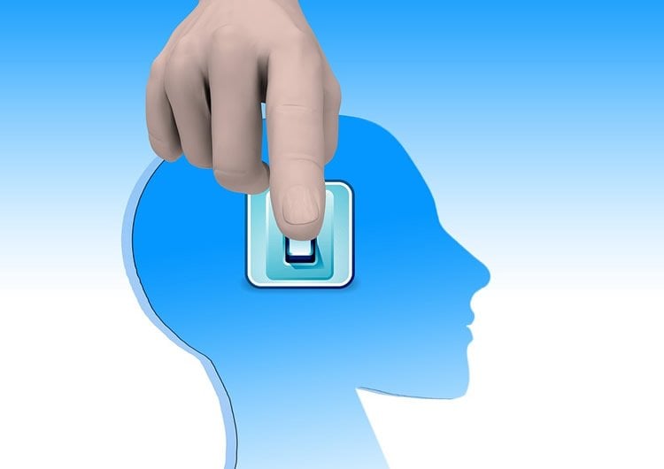 Image shows a person pushing a switch on a head.