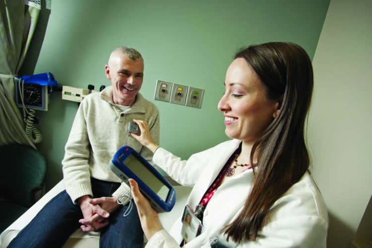Image shows a doctor and patient with Parkinson's.