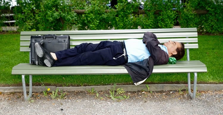 a man sleeping on a park bench
