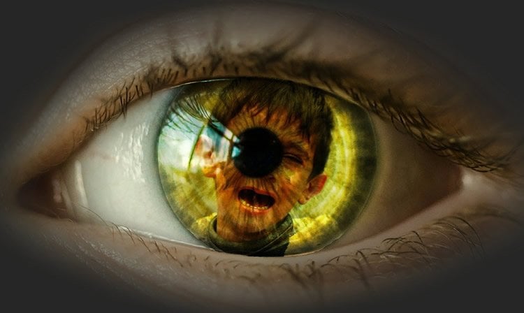 a child's eye with an image of a crying boy inside