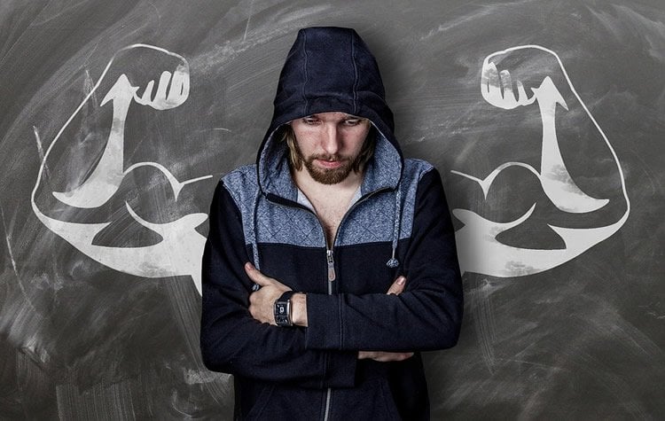 a man with muscular arms drawn behind him on a blackboard