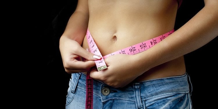 a woman measuring her belly