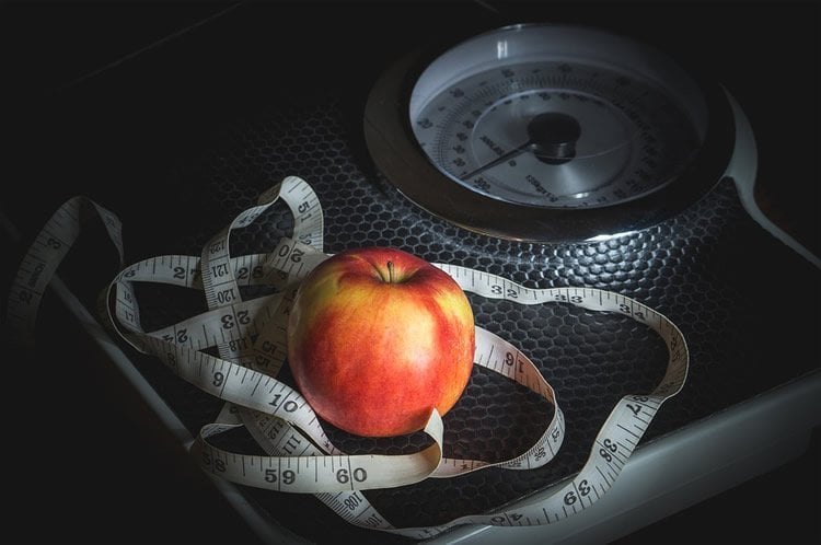 a scale, tape and apple