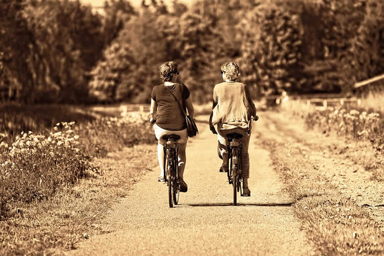 This shows two older ladies riding bikes