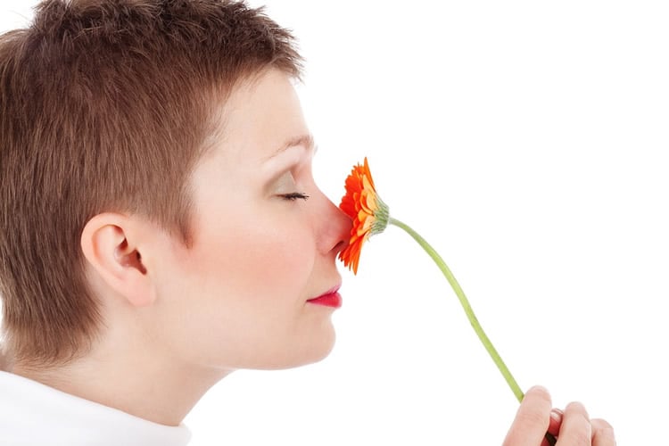 This is a woman smelling a flower