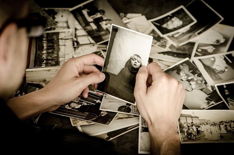 This shows a man looking at old photos