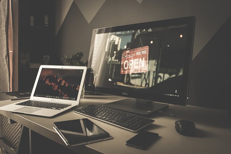 This image shows a laptop and a computer monitor at night time