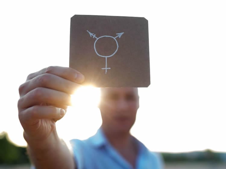 This shows a person holding up a gender sign on a piece of paper