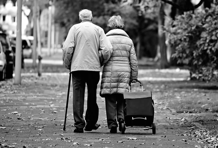 This image shows an old couple walking down a street.