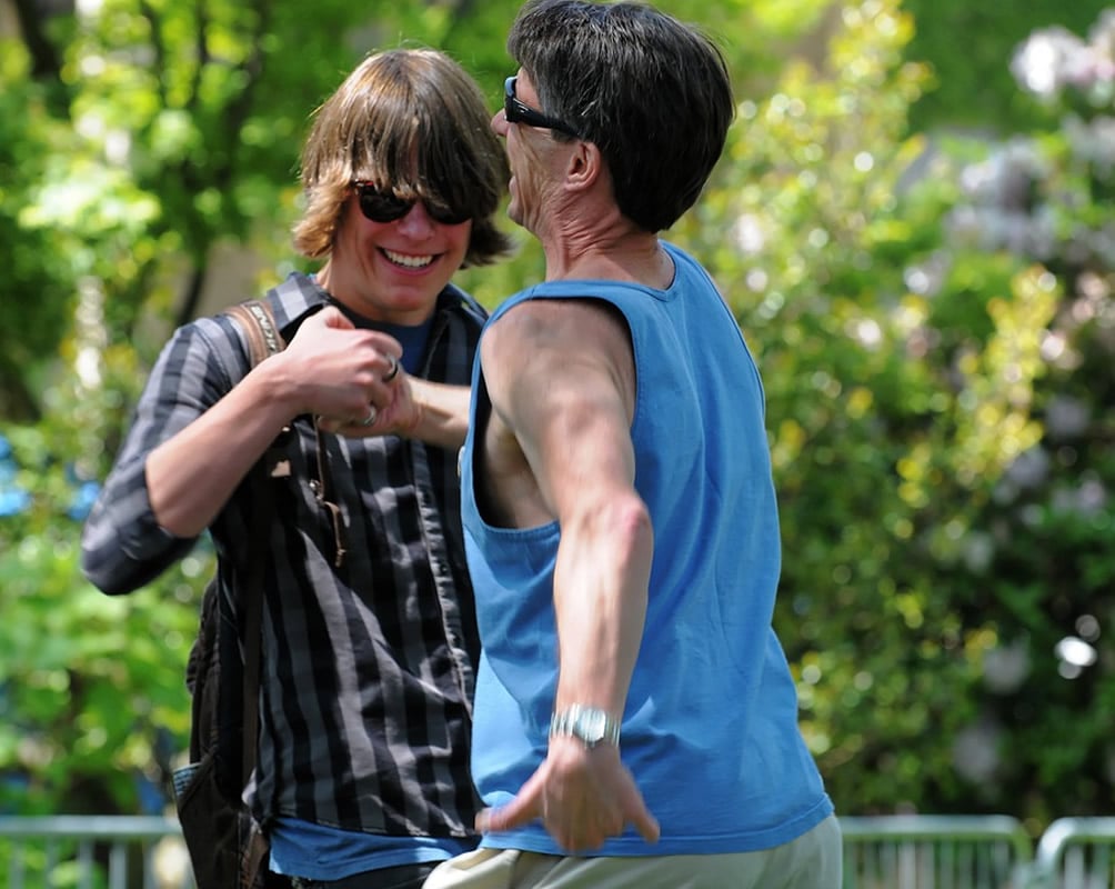 This shows a middle aged guy doing a cool handshake with a young dude