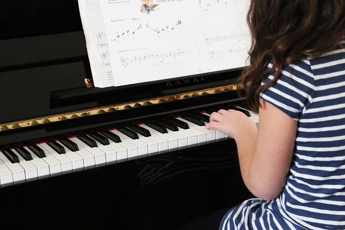 This shows a little girl playing the piano