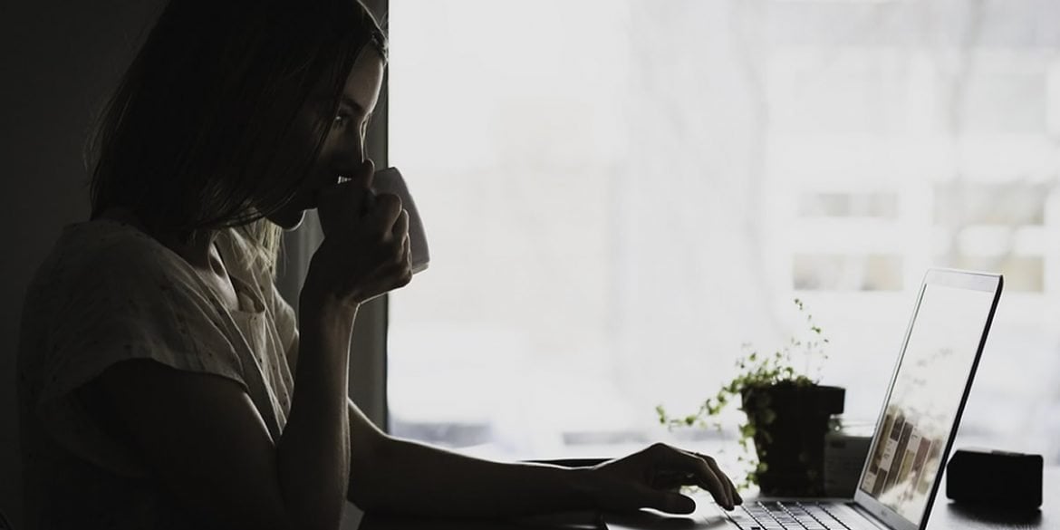 This shows a young woman working at a laptop computer