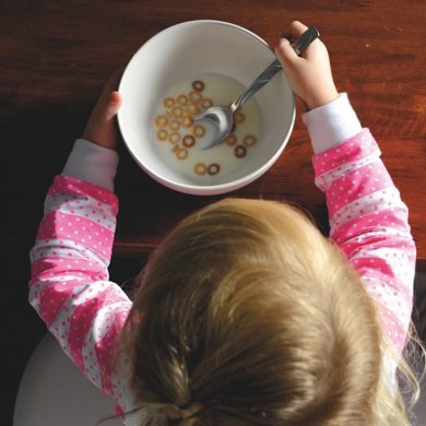 This shows a child staring at a bowl of cereal