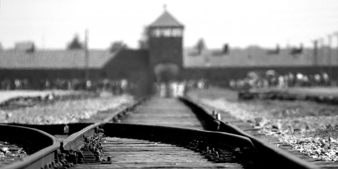 This shows the train track with the entrance to Auschwitz in the distance