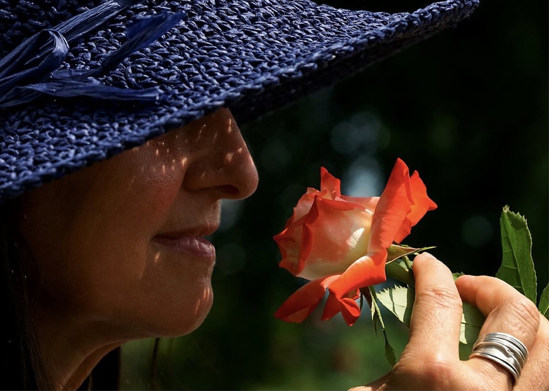 This shows a woman smelling a rose