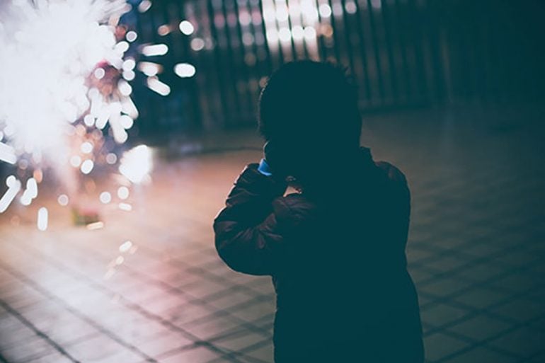 This shows a child covering their ears at fireworks